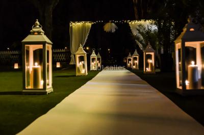 Chemin ombragé bordé d'arbres longeant une rivière calme, avec une barrière en bois sur le côté.