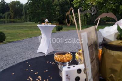 Une femme en robe de mariée défile sur un tapis rouge devant un public dans une salle éclairée par des lustres.