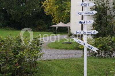 Salle de réunion avec une grande table en bois, chaises noires, bouteilles d'eau et vue sur l'extérieur par des baies…