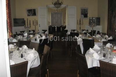 Salle de réunion avec une grande table en bois, chaises noires, bouteilles d'eau et vue sur l'extérieur par des baies…