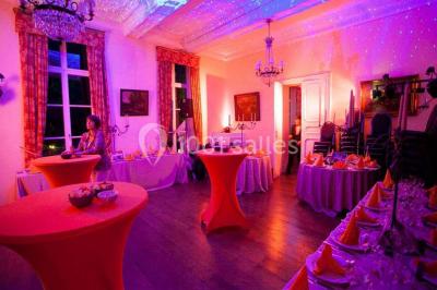 Salle de réunion avec une grande table en bois, chaises noires, bouteilles d'eau et vue sur l'extérieur par des baies…