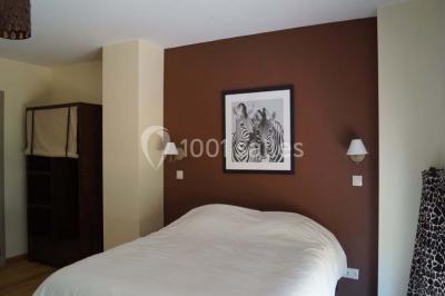 Salle de réunion avec une grande table en bois, chaises noires, bouteilles d'eau et vue sur l'extérieur par des baies…