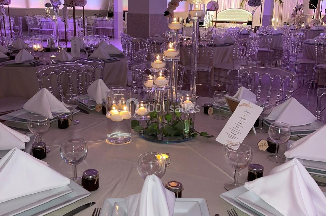 Location salle Brétigny-sur-Orge (Essonne) - La Joya Réception #12 Salle de réception décorée avec des tables élégantes, nappes beiges, bougies et éclairage violet tamisé.