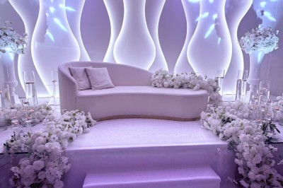 Décoration de salle avec fleurs roses, chandeliers dorés et rideaux scintillants dans un cadre élégant et lumineux.