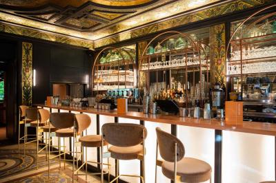 Miniature Location salle Paris 10 (Paris) - Delaville #7 Escalier en marbre avec rampes en fer forgé, colonnes décoratives et lustres suspendus dans un intérieur ancien.