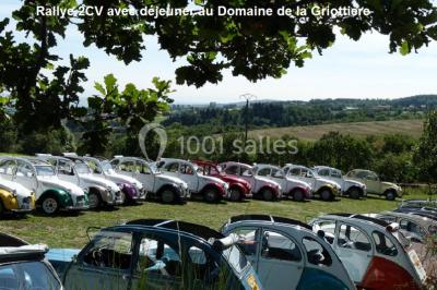 Un groupe de personnes posant debout dans une pièce avec des murs en pierre et une table en arrière-plan.