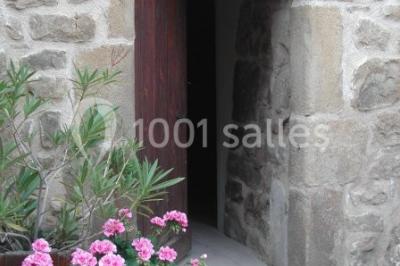 Un groupe de personnes posant debout dans une pièce avec des murs en pierre et une table en arrière-plan.