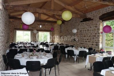 Un groupe de personnes posant debout dans une pièce avec des murs en pierre et une table en arrière-plan.
