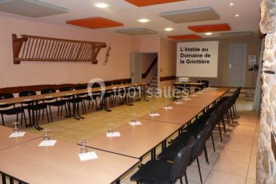Un groupe de personnes posant debout dans une pièce avec des murs en pierre et une table en arrière-plan.