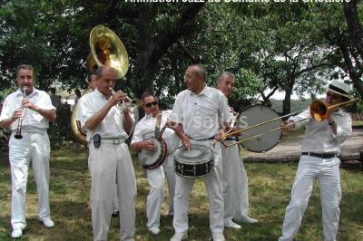 Un groupe de personnes posant debout dans une pièce avec des murs en pierre et une table en arrière-plan.