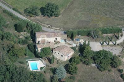 Un groupe de personnes posant debout dans une pièce avec des murs en pierre et une table en arrière-plan.