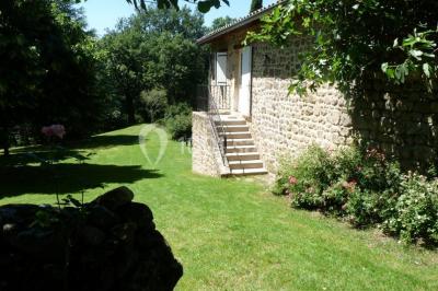 Un groupe de personnes posant debout dans une pièce avec des murs en pierre et une table en arrière-plan.