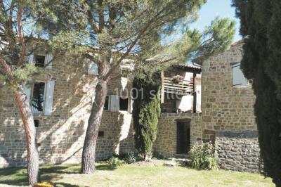 Un groupe de personnes posant debout dans une pièce avec des murs en pierre et une table en arrière-plan.