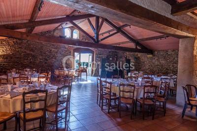 Décoration florale composée de roses, pivoines et feuillage, accrochée à une structure blanche en extérieur.