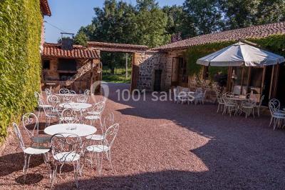 Décoration florale composée de roses, pivoines et feuillage, accrochée à une structure blanche en extérieur.