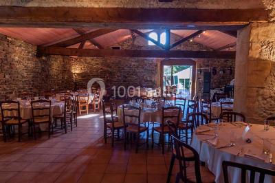 Décoration florale composée de roses, pivoines et feuillage, accrochée à une structure blanche en extérieur.