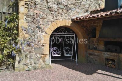 Décoration florale composée de roses, pivoines et feuillage, accrochée à une structure blanche en extérieur.