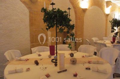 Décoration florale composée de roses, pivoines et feuillage, accrochée à une structure blanche en extérieur.