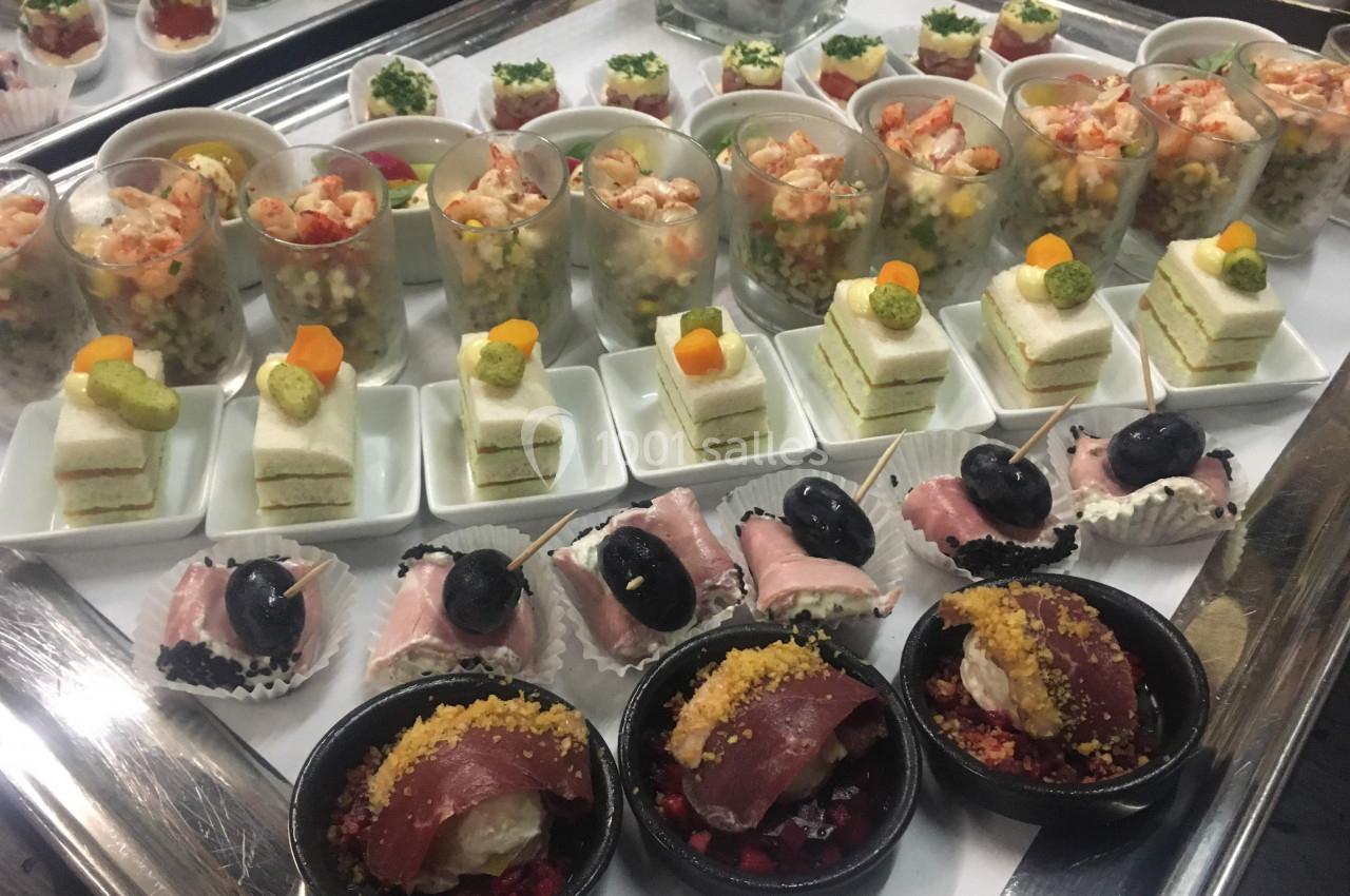 Plateau de bouchées apéritives variées comprenant verrines, mini-sandwichs, charcuteries et sushis.