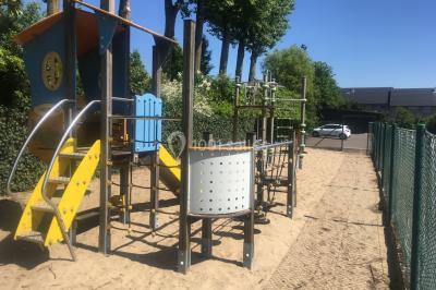 Miniature Location salle Mouscron (Hainaut) - La Renaissance #22 Structure de jeux en plein air avec toboggan et modules d'escalade, installée sur un sol sablonneux près d'une clôture.