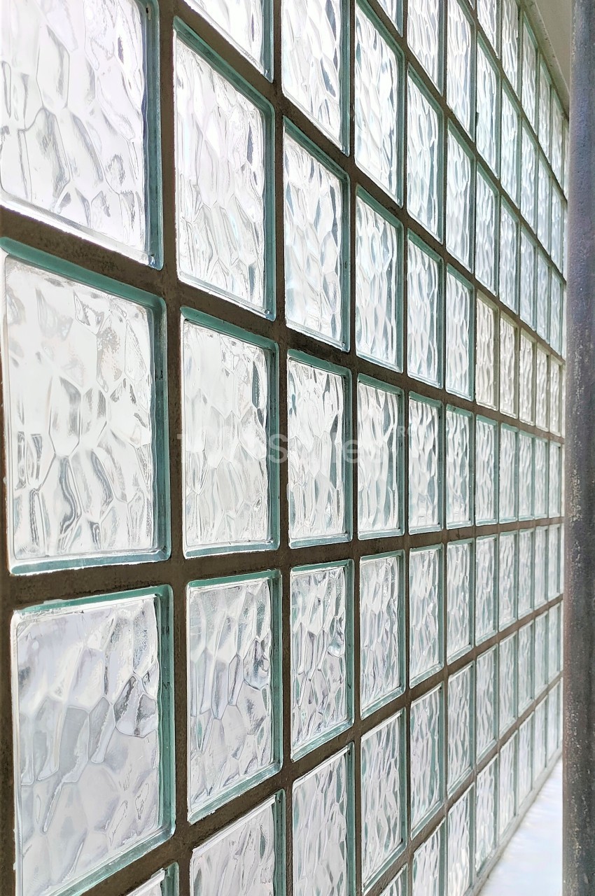 Mur composé de carreaux de verre translucides laissant passer la lumière tout en préservant l'intimité.