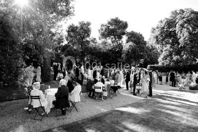 Miniature Location salle Piolenc (Vaucluse) - Château Beauchêne #6 Un couple en tenue de mariage sourit sur les marches d'un escalier en pierre devant une maison entourée de végétation.