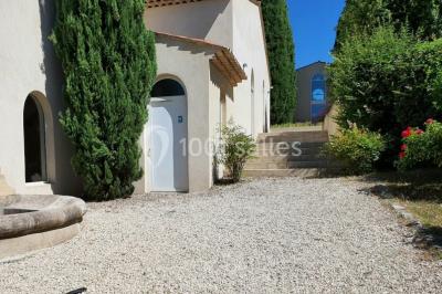 Salle avec de grandes presses anciennes en bois et une longue table dressée pour un repas.