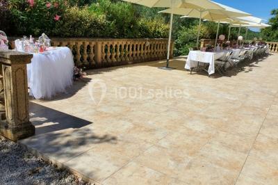 Salle avec de grandes presses anciennes en bois et une longue table dressée pour un repas.