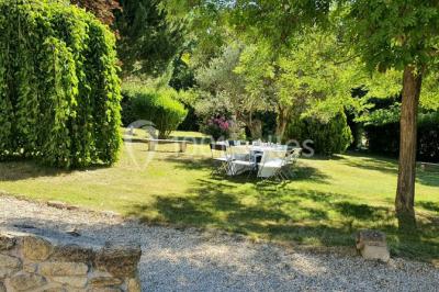 Salle avec de grandes presses anciennes en bois et une longue table dressée pour un repas.