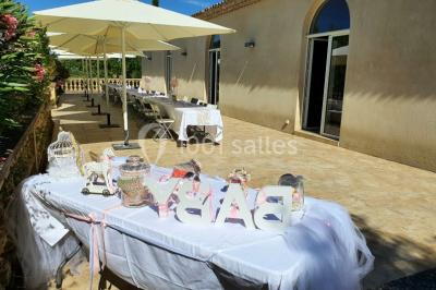 Salle avec de grandes presses anciennes en bois et une longue table dressée pour un repas.