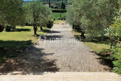 Salle avec de grandes presses anciennes en bois et une longue table dressée pour un repas.