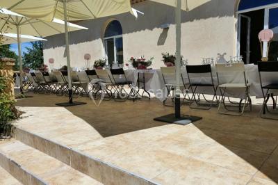 Salle avec de grandes presses anciennes en bois et une longue table dressée pour un repas.