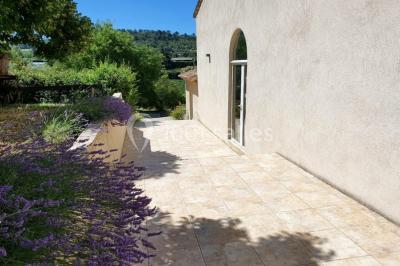 Salle avec de grandes presses anciennes en bois et une longue table dressée pour un repas.