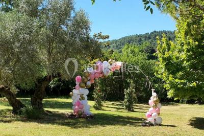 Salle avec de grandes presses anciennes en bois et une longue table dressée pour un repas.