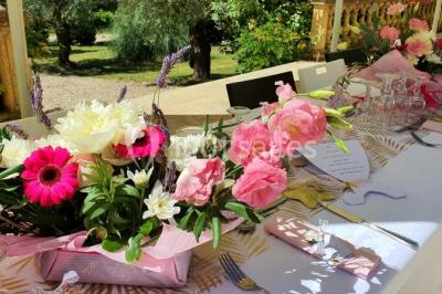 Salle avec de grandes presses anciennes en bois et une longue table dressée pour un repas.