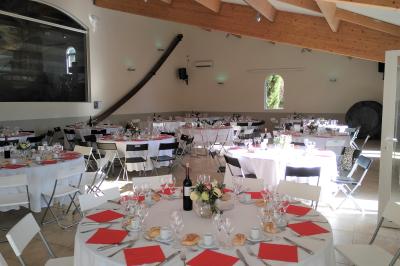 Salle avec de grandes presses anciennes en bois et une longue table dressée pour un repas.