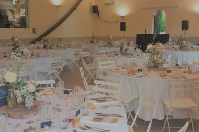 Salle avec de grandes presses anciennes en bois et une longue table dressée pour un repas.