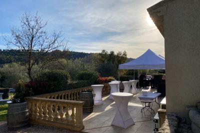 Salle avec de grandes presses anciennes en bois et une longue table dressée pour un repas.