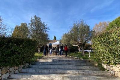 Salle avec de grandes presses anciennes en bois et une longue table dressée pour un repas.