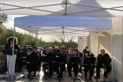 Salle avec de grandes presses anciennes en bois et une longue table dressée pour un repas.