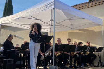 Salle avec de grandes presses anciennes en bois et une longue table dressée pour un repas.