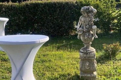 Salle avec de grandes presses anciennes en bois et une longue table dressée pour un repas.