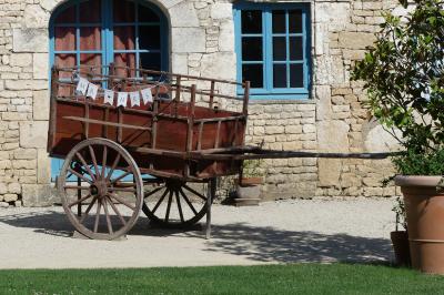 Miniature Location salle Sainte-Gemme-la-Plaine (Vendée) - Château de la Chevallerie #25 Un couple marche dans le jardin d'un château ancien entouré de verdure par une journée ensoleillée.