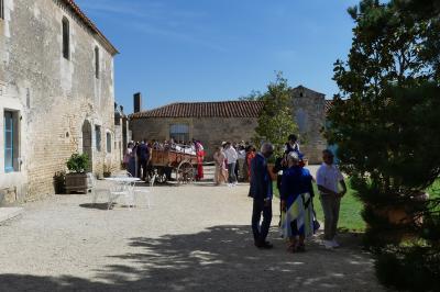 Miniature Location salle Sainte-Gemme-la-Plaine (Vendée) - Château de la Chevallerie #13 Un couple marche dans le jardin d'un château ancien entouré de verdure par une journée ensoleillée.
