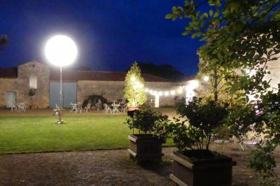 Miniature Location salle Sainte-Gemme-la-Plaine (Vendée) - Château de la Chevallerie #26 Un couple marche dans le jardin d'un château ancien entouré de verdure par une journée ensoleillée.