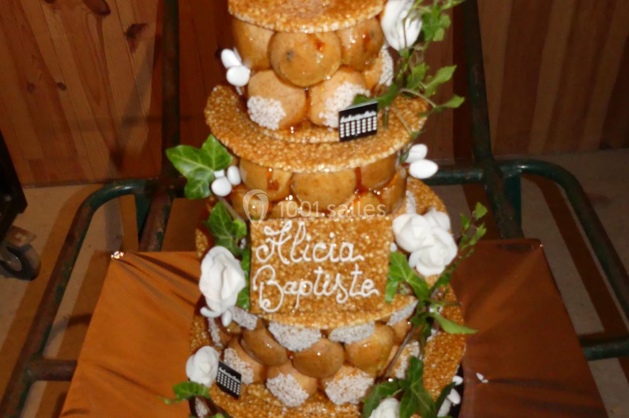 Location salle Sainte-Gemme-la-Plaine (Vendée) - Château de la Chevallerie #29 Pièce montée en choux décorée de feuilles, fleurs en sucre et inscription ’Alicia Baptiste’ sur une plaque.