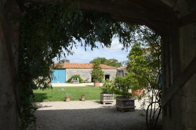 Miniature Location salle Sainte-Gemme-la-Plaine (Vendée) - Château de la Chevallerie #42 Un couple marche dans le jardin d'un château ancien entouré de verdure par une journée ensoleillée.