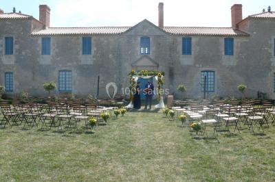 Miniature arche classique Un couple marche dans le jardin d'un château ancien entouré de verdure par une journée ensoleillée.