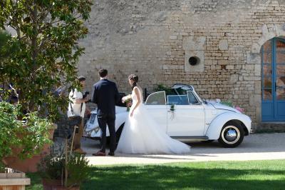 Miniature Arrivée des mariés Un couple marche dans le jardin d'un château ancien entouré de verdure par une journée ensoleillée.