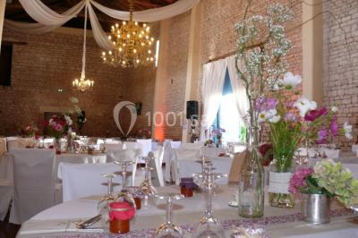 Miniature fleurs des champs Un couple marche dans le jardin d'un château ancien entouré de verdure par une journée ensoleillée.